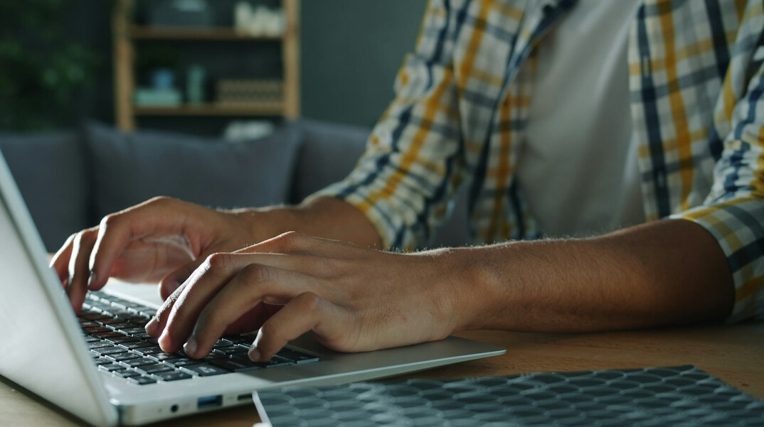 Photographer editing photos at a desk with a laptop