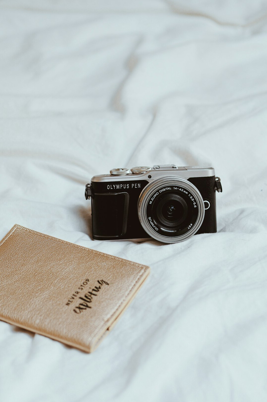Camera and notebook flat lay on a wooden desk