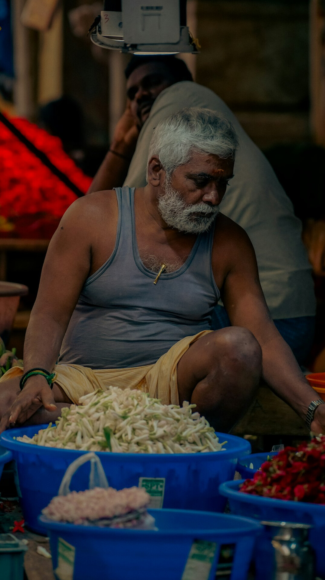 Elderly man selling vegetables at a local market