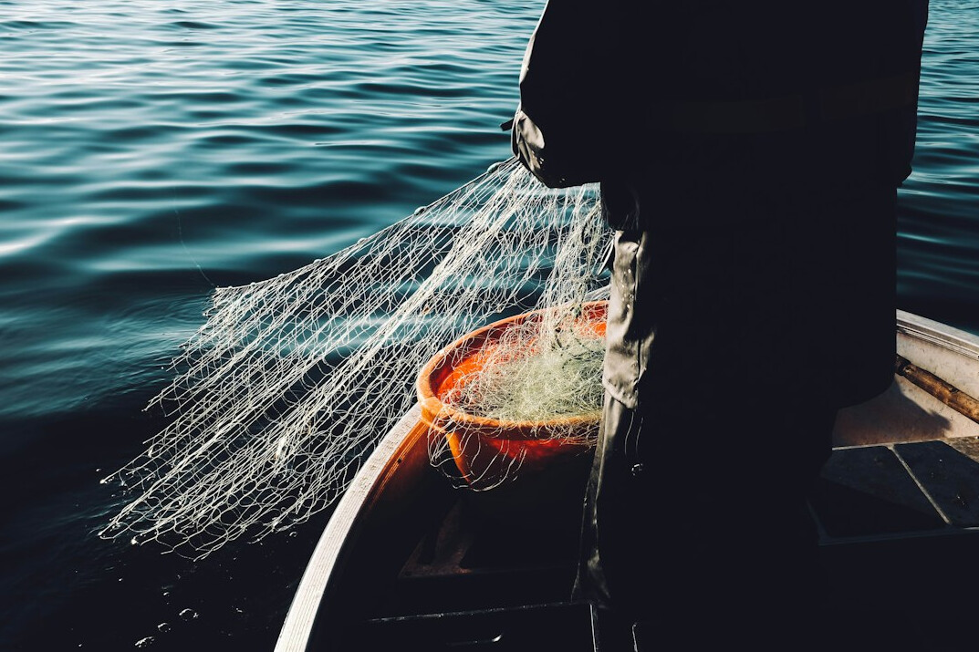 Fisherman mending nets on a lake shore in Poland
